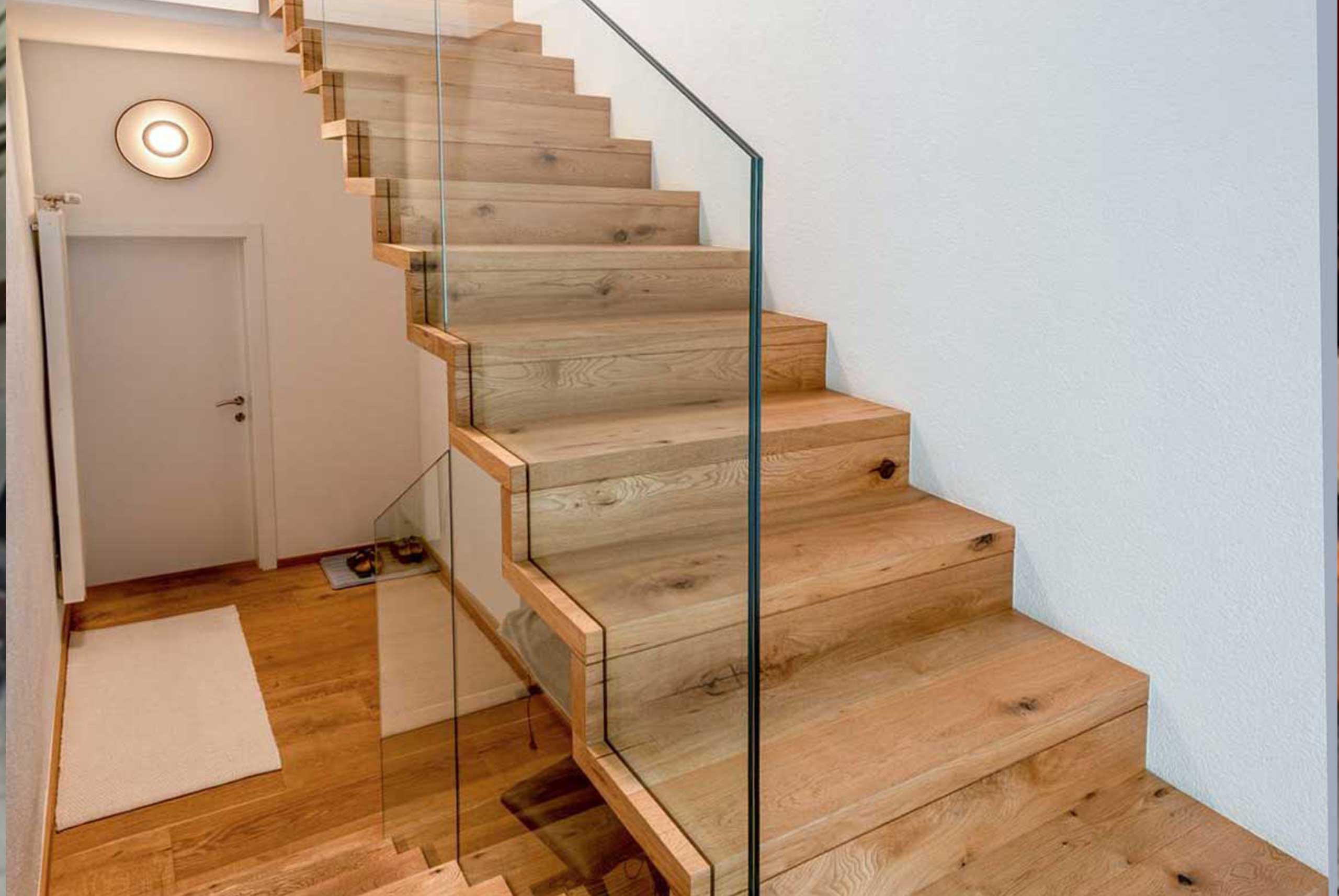 Moderne Treppe mit Glasgeländer und Holzstiegen